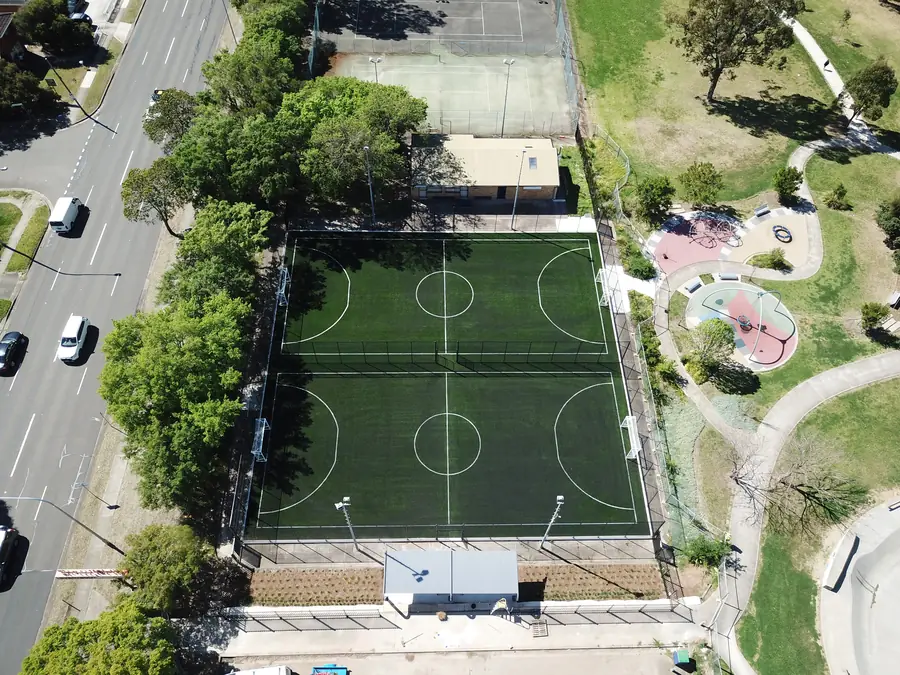 Aerial view of two synthetic grass futsal pitches beside a playground at Emerson Park
